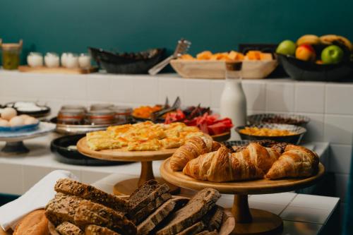 a table with two pizzas and croissants and bread at About Sololaki in Tbilisi City