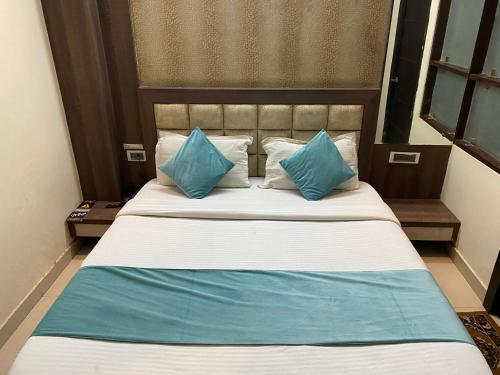 a bed with blue pillows in a hotel room at Hotel Royal Galaxy in Faithfulganj