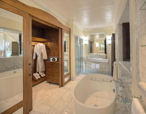 een grote badkamer met een bad en een wastafel bij Hemingways Nairobi in Nairobi