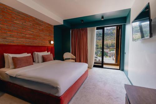 ein Schlafzimmer mit einem Bett und einer Ziegelwand in der Unterkunft About Sololaki in Tbilisi City