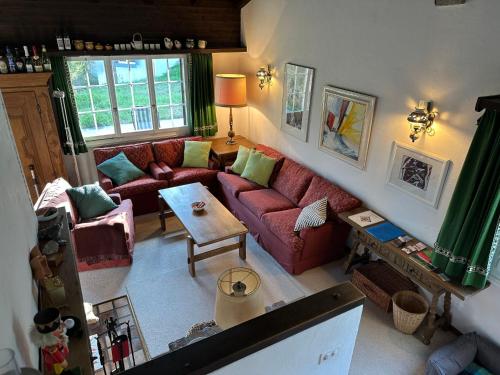 einen Blick über ein Wohnzimmer mit einem roten Sofa in der Unterkunft Chalet Tgaplotta by Interhome in Alvaneu