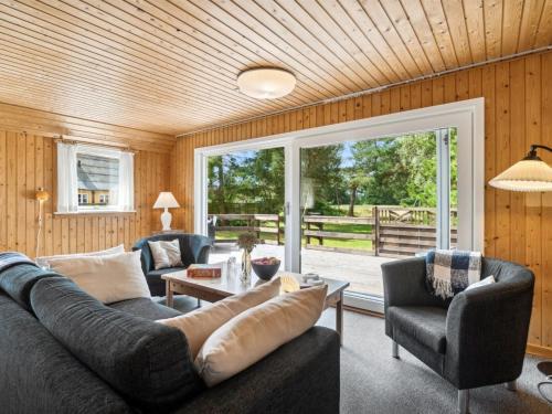 ein Wohnzimmer mit einem Sofa, einem Tisch und Stühlen in der Unterkunft Holiday Home Hillmari - 650m from the sea in Bornholm by Interhome in Vester Sømarken