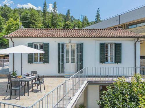 a white house with a table and chairs and an umbrella at Holiday Home Casa di Giò by Interhome in Marina di Massa