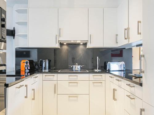 eine weiße Küche mit weißen Schränken und Geräten in der Unterkunft Apartment Vasco de Gama B6-R by Interhome in Bouveret