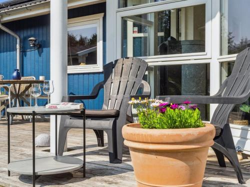 twee stoelen en een tafel en een pot met bloemen bij Holiday Home Asvalde - all inclusive - 200m to the inlet by Interhome in Vordingborg