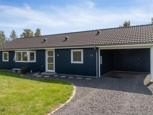 een blauw huis met een garage bij Holiday Home Asvalde - all inclusive - 200m to the inlet by Interhome in Vordingborg