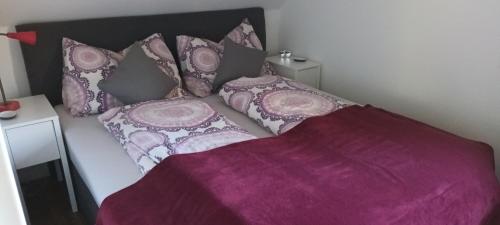 Una cama con sábanas y almohadas moradas. en Hideaway, en Zell am Moos