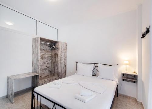 a small bedroom with a white bed with white pillows at Filippa City Apartments - Lefkada Town Center in Lefkada