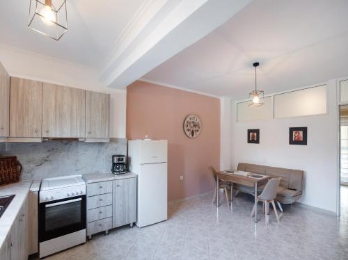 a kitchen with a white refrigerator and a table at Filippa City Apartments - Lefkada Town Center in Lefkada