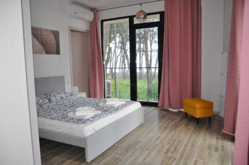 a bedroom with a bed and a large window at Apartmany Paradiso Shekvetili in Shekvetili