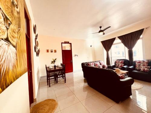 a living room with a couch and a table at Apex Mbweni Apartment in Kiembi Samaki