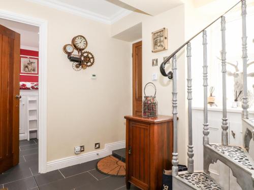 a hallway with stairs and a clock on the wall at The Lantern in Kendal