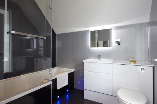 a white bathroom with a toilet and a sink at Luccombe Hall Hotel in Shanklin