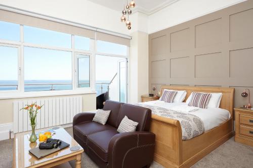 a bedroom with a bed and a couch at Luccombe Hall Hotel in Shanklin