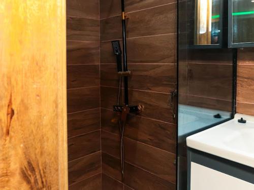 y baño con ducha y pared de madera. en Luxury home with class, en Accra