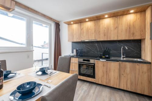 a kitchen with wooden cabinets and a table with a sink at TOP 8 Apartment - Zell am See - Kaprun in Piesendorf