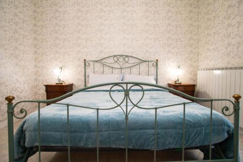 a bedroom with a metal bed with a blue blanket at La Villa dei Tartufi - B&B in Corfinio