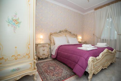 1 dormitorio con 1 cama con colcha púrpura en La Villa dei Tartufi - B&B en Corfinio