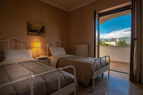 a bedroom with two beds and a door to a balcony at La Villa dei Tartufi - B&B in Corfinio