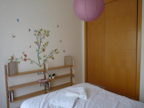 ein Schlafzimmer mit einem Bett mit einem Blumenbild an der Wand in der Unterkunft 2010-Superb apt 2 bedrooms in complex with pool in Manilva