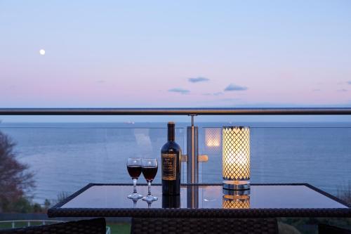 a table with two glasses and a bottle of wine at Luccombe Hall Hotel in Shanklin