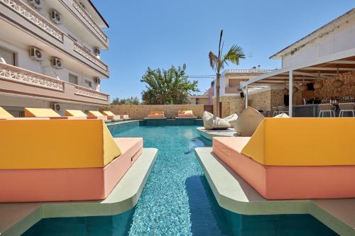 einen Pool in einem Hotel mit bunten Stühlen in der Unterkunft Asana Hotel in Analipsi