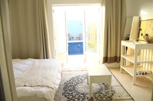 a bedroom with a bed and a table and a window at GreenLand in Bir Jedíd Saint-Hubert
