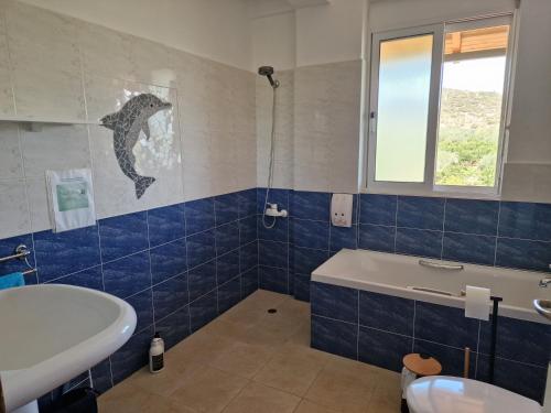 a bathroom with a tub and a sink and a bath tub at Grieks vakantiehuis To Kalokairi in Kalamákion