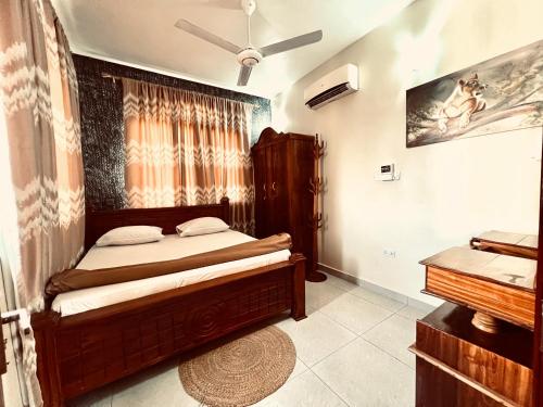 1 dormitorio con cama de madera y piano en Africa Mbweni Apartment, en Kiembi Samaki