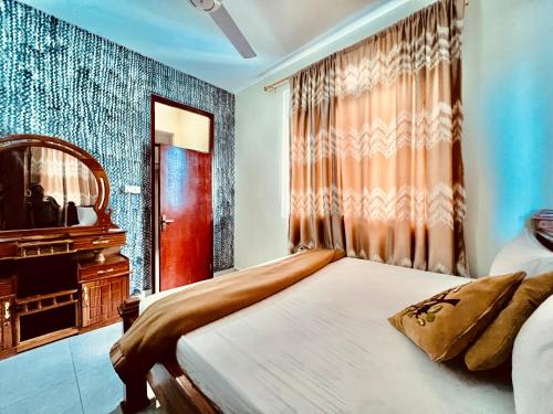 a bedroom with a bed and a mirror and a window at Apex Mbweni Apartment in Kiembi Samaki