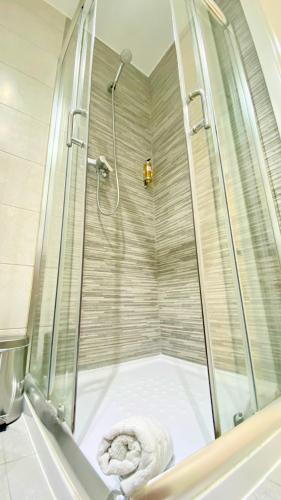 a shower with a glass door in a bathroom at Casa Amarela Guesthouse in Albufeira