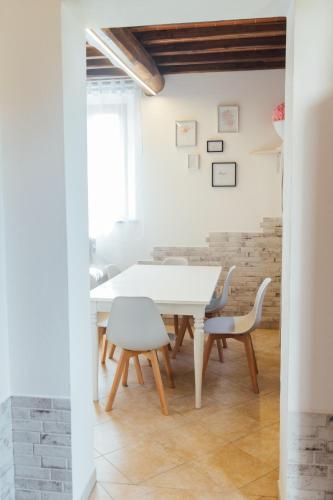 a dining room with a white table and chairs at Country Chic Pistoia-casa in campagna giardino, parking in Pistoia