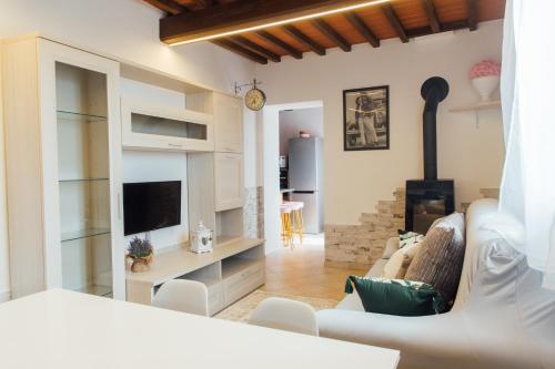 uma sala de estar com um sofá e uma televisão em Country Chic Pistoia-casa in campagna con giardino em Pistoia