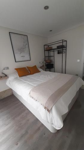 un grande letto bianco in una camera da letto bianca di Zuvillaga 14 a Oviedo