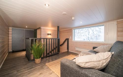 - un salon avec un canapé et une fenêtre dans l'établissement Rukan Rinnemaa B, à Kuusamo