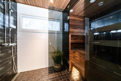 uma casa de banho com um chuveiro e uma porta de vidro em Rukan Rinnemaa B em Kuusamo