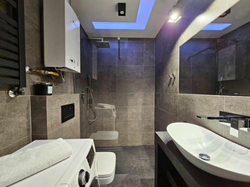 a bathroom with a white sink and a toilet at Apartament w centrum miasta z balkonem in Jastrzębie Zdrój