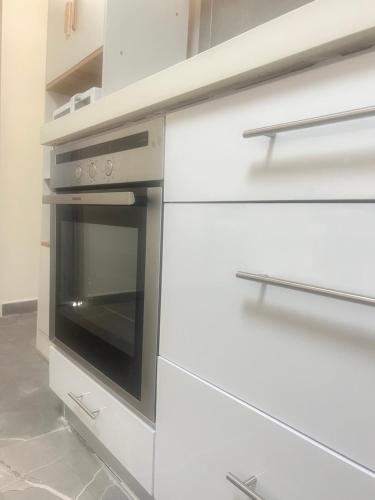 a kitchen with white cabinets and an oven at Buchman Cozy 1Bedroom Haven in Modi'in