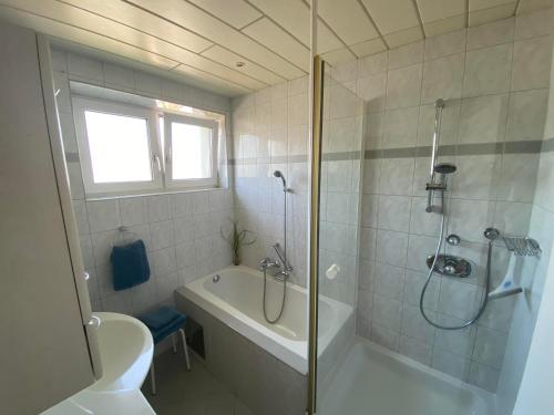 e bagno con doccia, vasca e servizi igienici. di Ferienwohnung Nussbaumblick a Ottensheim