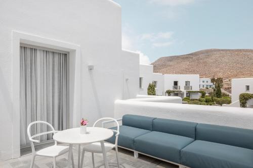 a living room with a blue couch and a table at ANEMI Folegandros in Karavostasi