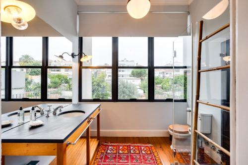 een badkamer met een wastafel en grote ramen bij Porto Premium Villa in Porto