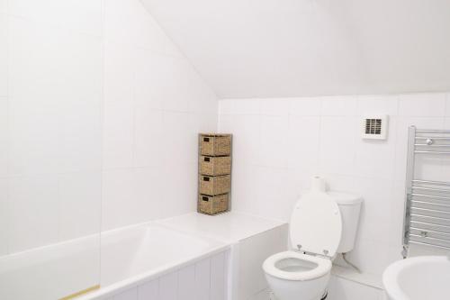 a white bathroom with a toilet and a sink at Bee Stays - Crossbar Hotel One-Bedroom Flats in Warrington