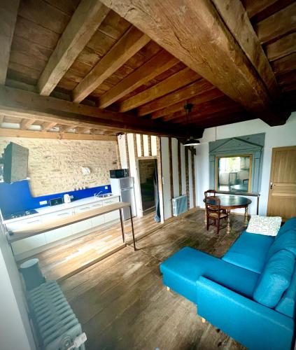 un salon avec un canapé bleu et une table dans l'établissement Appartement au manoir de la grande vigne Mayenne, à Mayenne