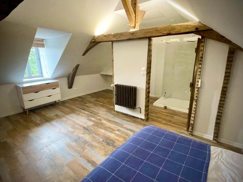 an attic bathroom with a shower and a blue rug at Appartement au manoir de la grande vigne Mayenne in Mayenne