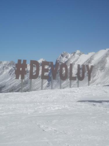 a sign in the snow in front of a mountain at Studio LE CLEMARION - SUPERDEVOLUY in Le Dévoluy