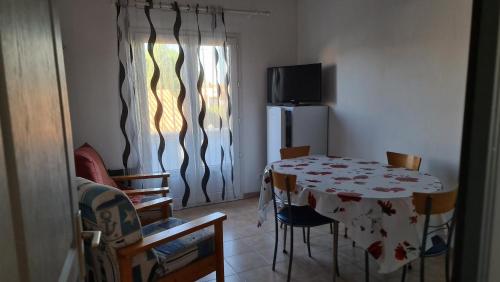 une pièce avec une table, des chaises et une télévision dans l'établissement Appartement proche bord de mer (250m), 1er étage villa, au Grau-dʼAgde