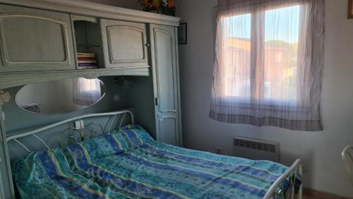 une chambre avec un lit, un miroir et une fenêtre dans l'établissement Appartement proche bord de mer (250m), 1er étage villa, au Grau-dʼAgde