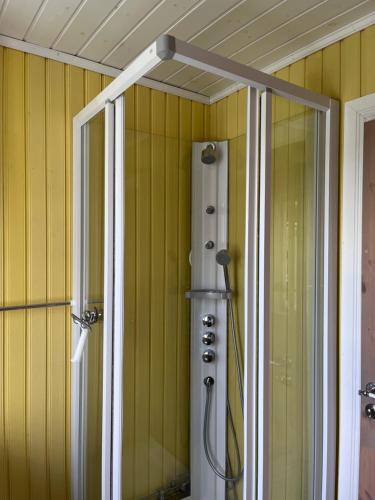 y baño con ducha y paredes de color amarillo. en Calm surroundings with hiking trails near Bodø and Saltstraumen en Bodø