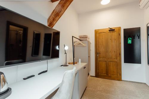 a bathroom with a white counter and a wooden door at Boutique Hotel Siglisberg in Štiavnické Bane