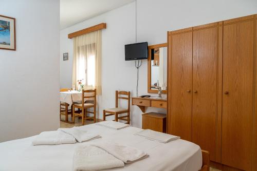 a bedroom with a bed and a desk and a table at Akrotiri Apartments in Makry Gialos
